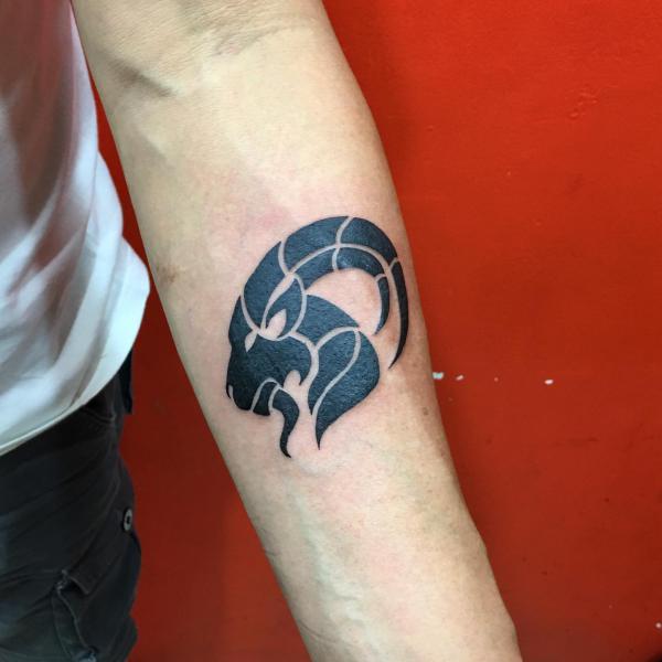Tribal Capricorn sea goat tattoo on forearm