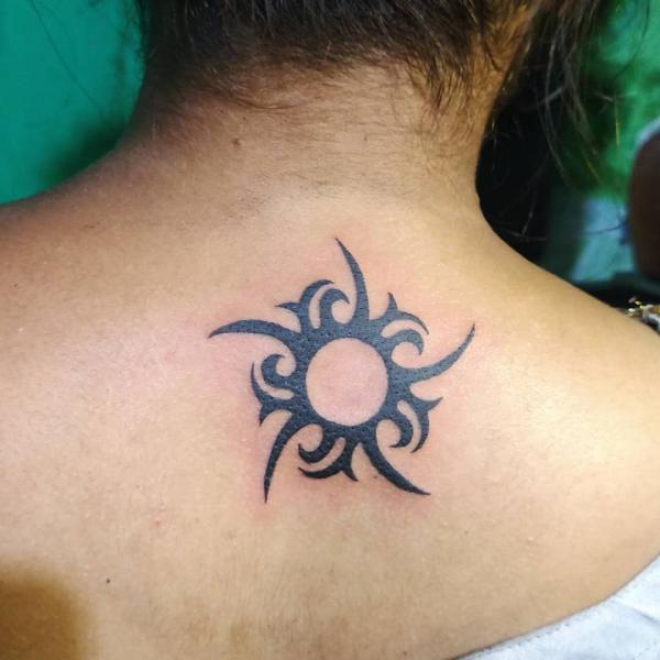 Tribal sun tattoo on upper back