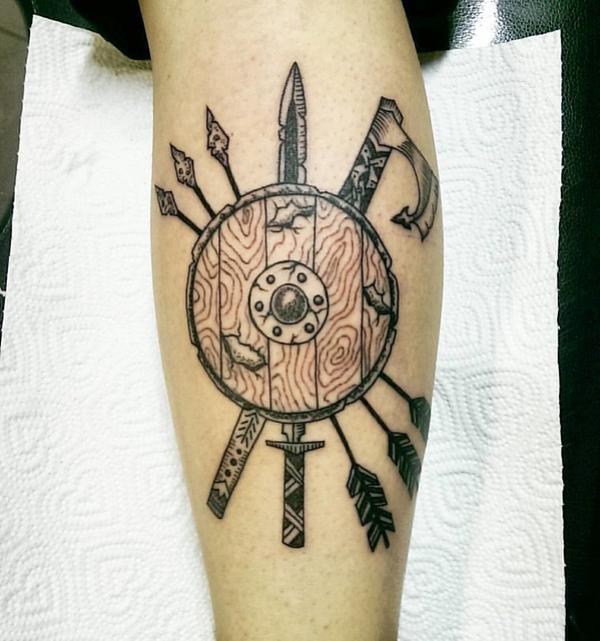 Viking shield tattoo with arrows axe and sword