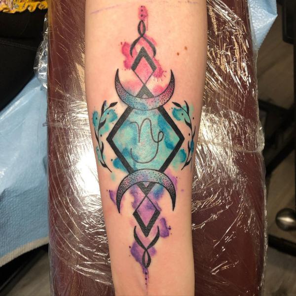 Watercolor geometric Capricorn tattoo forearm