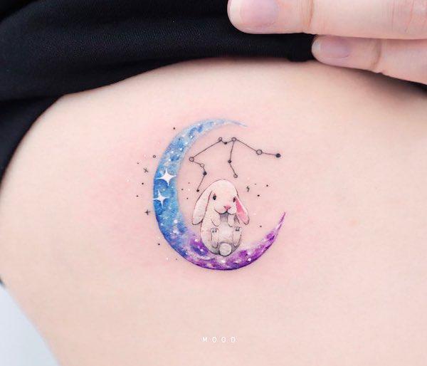 White rabbit with Aquarius constellation and crescent moon tattoo