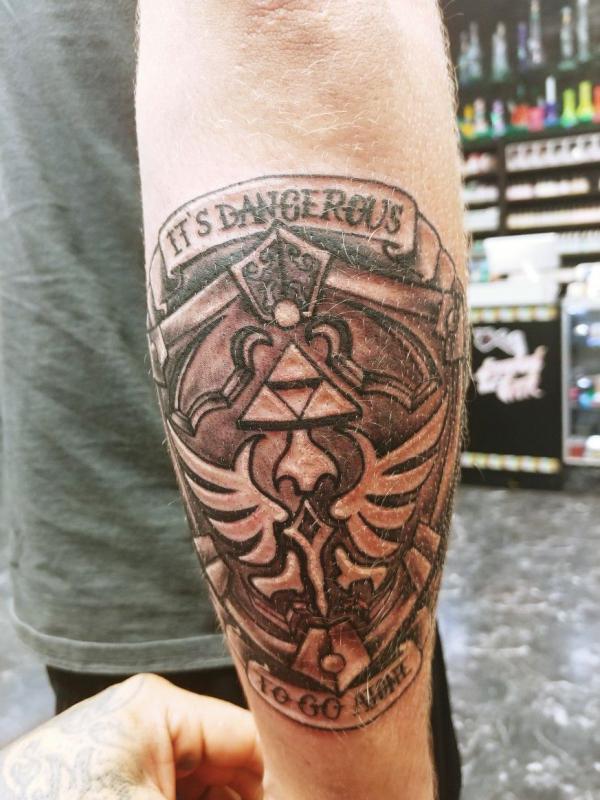 hylian shield tattoo on outer forearm