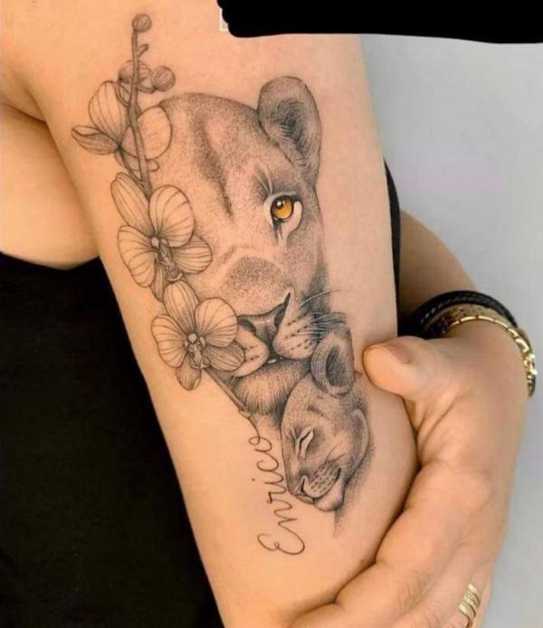 lioness and cub with orchid tattoo on upper arm