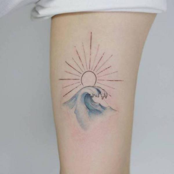 ocean sun and wave tattoo arm