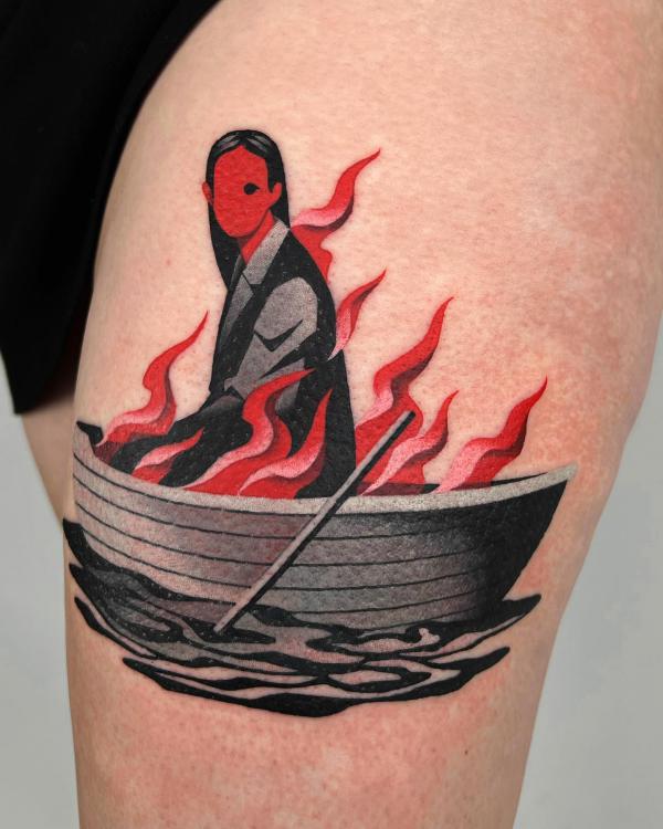 A woman in boat and fire tattoo thigh