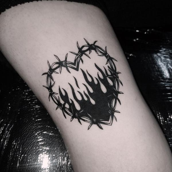 Black and white barbed wire heart in fire tattoo