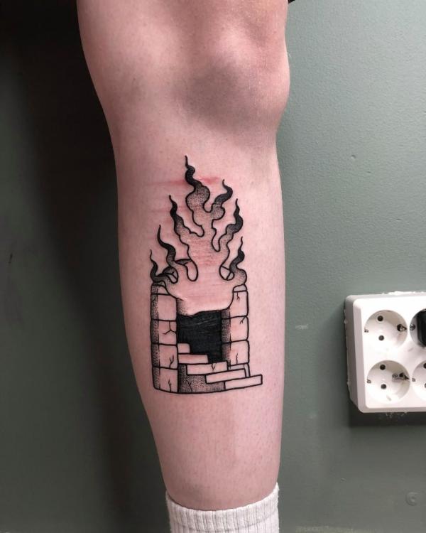 Black and white fire tattoo on lower leg