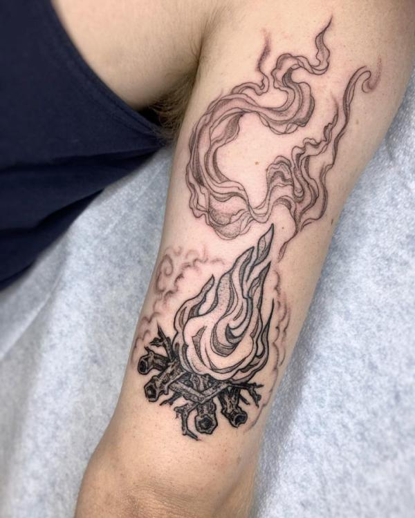 Black and white fire tattoo on upper arm