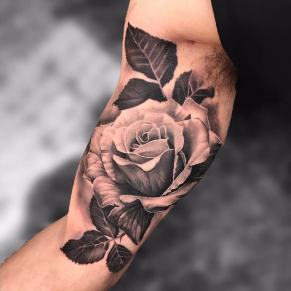 Black and white rose bicep tattoo