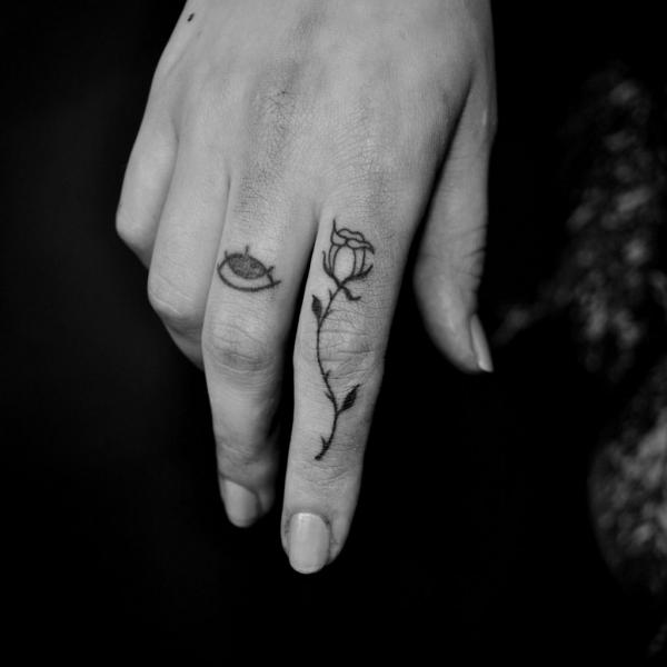 Black and white rose finger tattoo