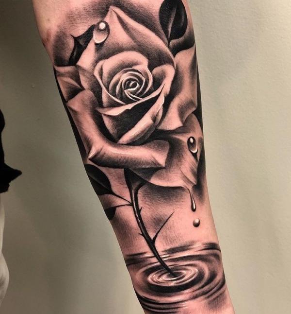 Black and white rose with thorns and water droplets tattoo