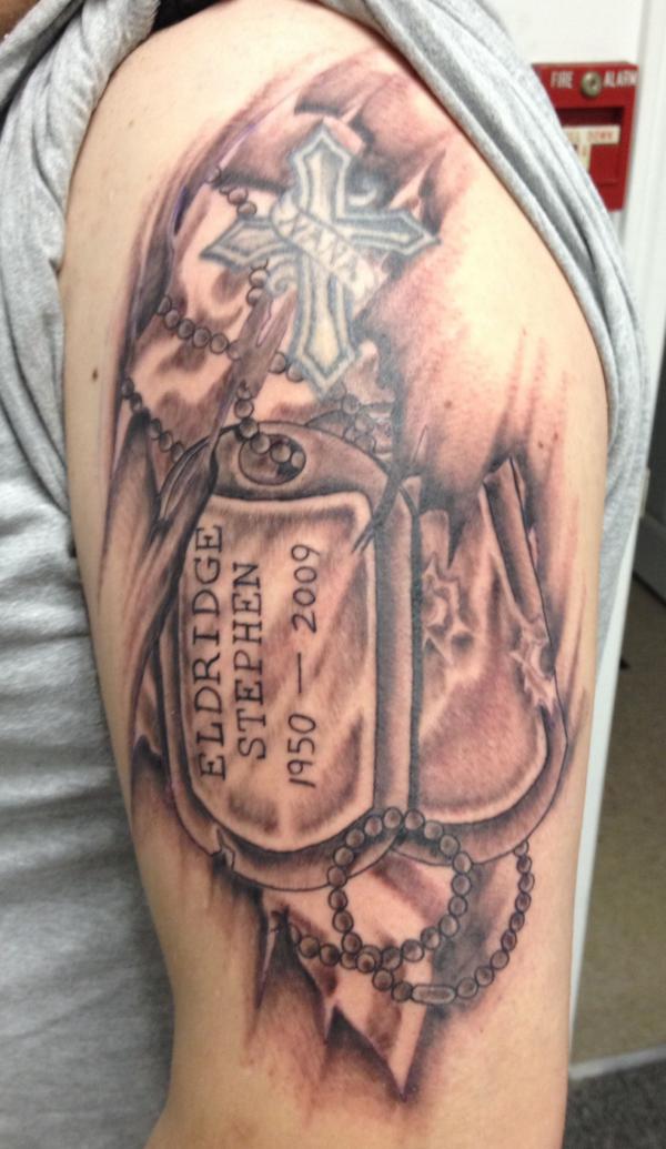 Cross and dog tag tattoo upper arm