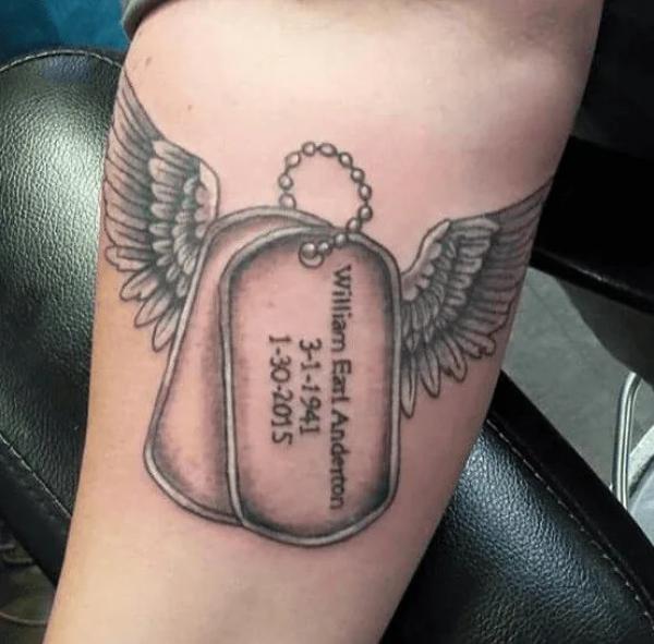 Dog tag with wings arm tattoo