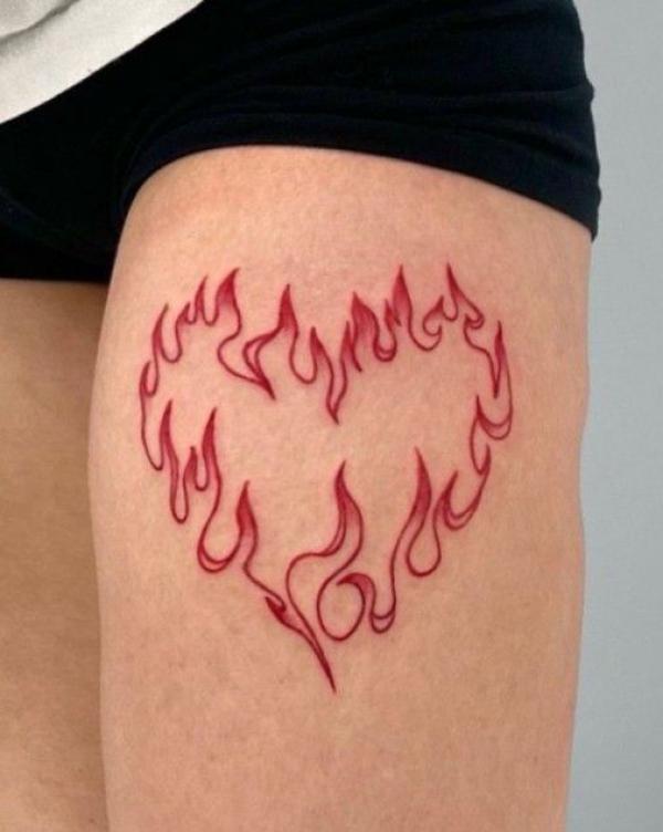 Firing heart outline thigh tattoo