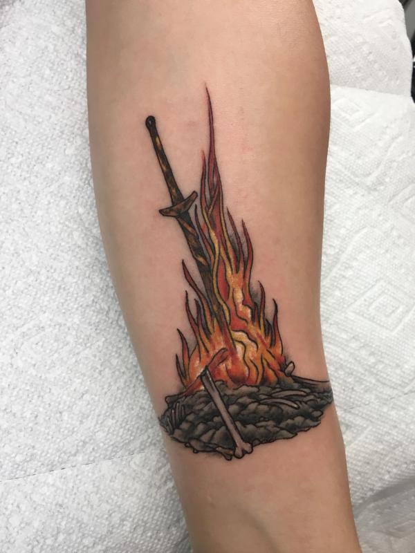 Flame and sword tattoo on arm