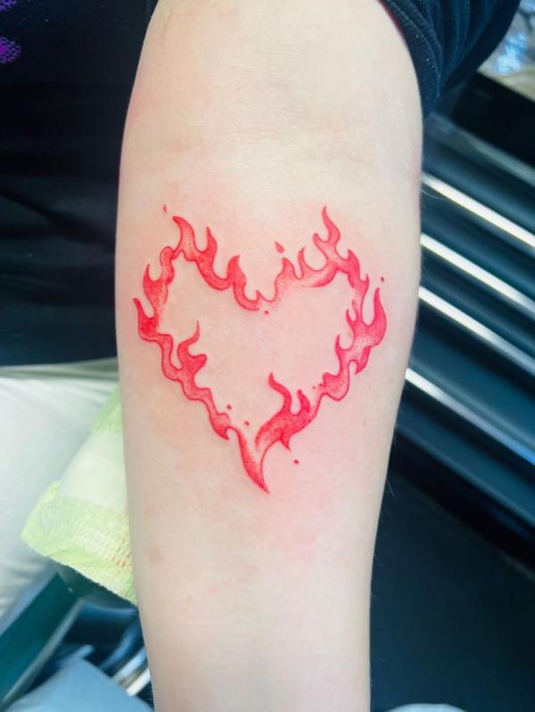 Flamed heart tattoo on forearm