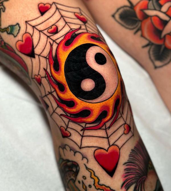 Flaming Yin Yang and spider web knee tattoo