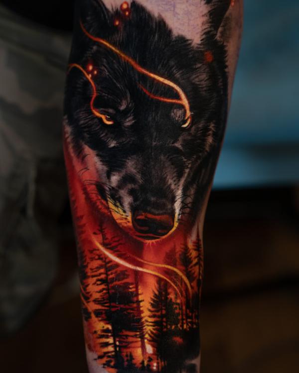 Forest and wolf in fire tattoo