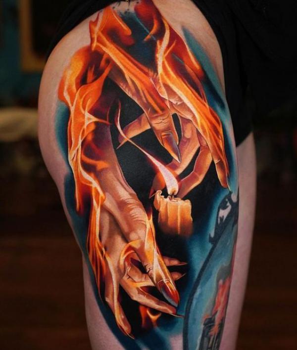 Hands and candle in flame thigh tattoo