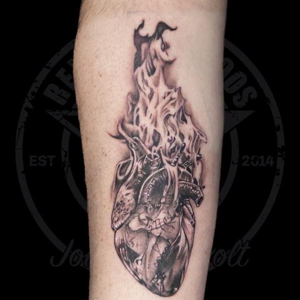 Human heart in flame tattoo black and grey