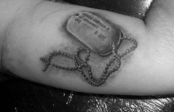 Realistic dog tag tattoo on forearm