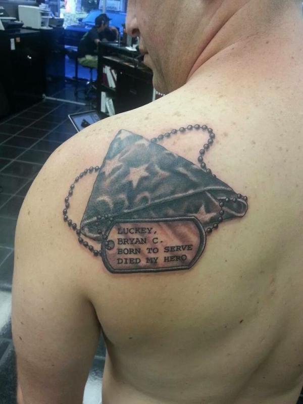 Shoulder blade dog tag and American flag tattoo