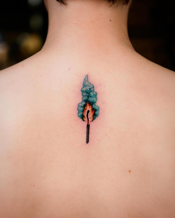 Small match lit flame tattoo on back