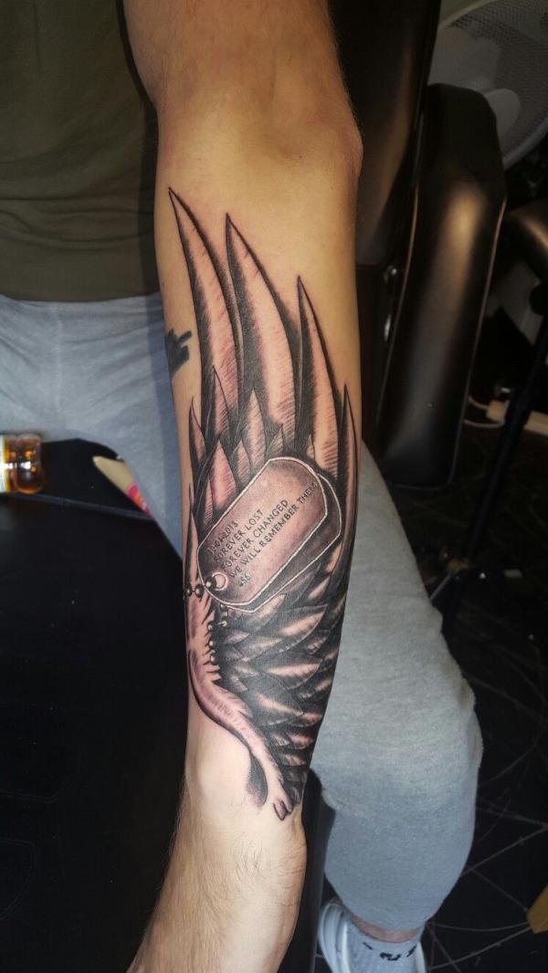Wings and dog tag tattoo forearm