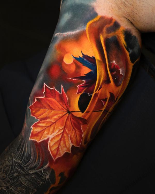 maple leaf in flame bicep tattoo