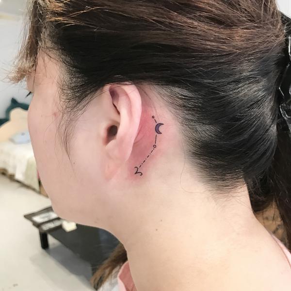 Aries and constellation with crescent moon tattoo behind the ear