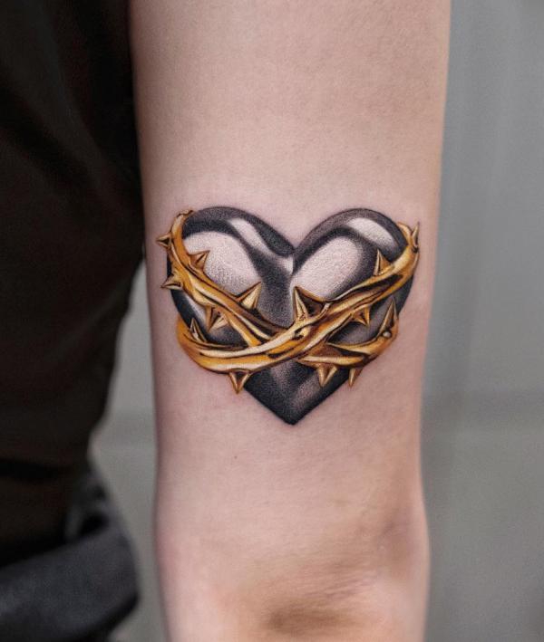 Barbed wire wrapped heart symbol tricep tattoo