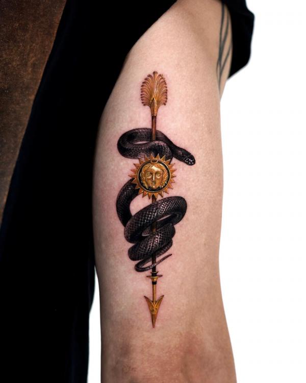 Black snake and golden arrow tricep tattoo