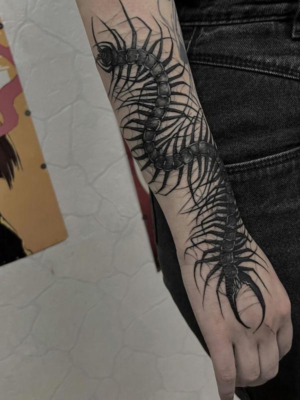 Blackwork centipede tattoo from forearm to hand