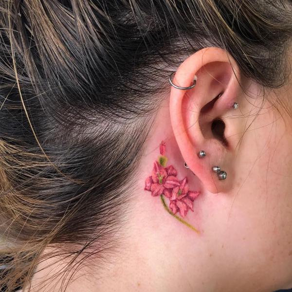 Dainty gladiolus tattoo behind ear