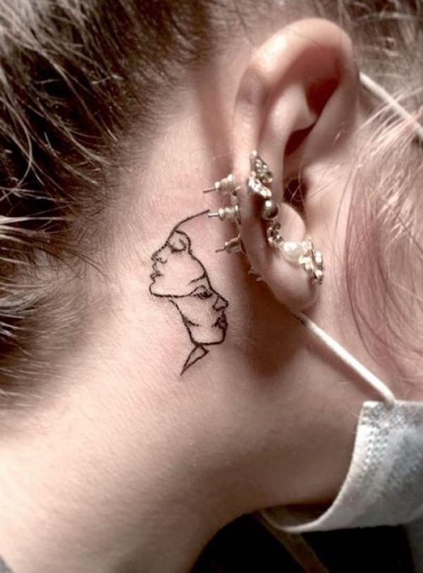 Gemini face tattoo behind ear