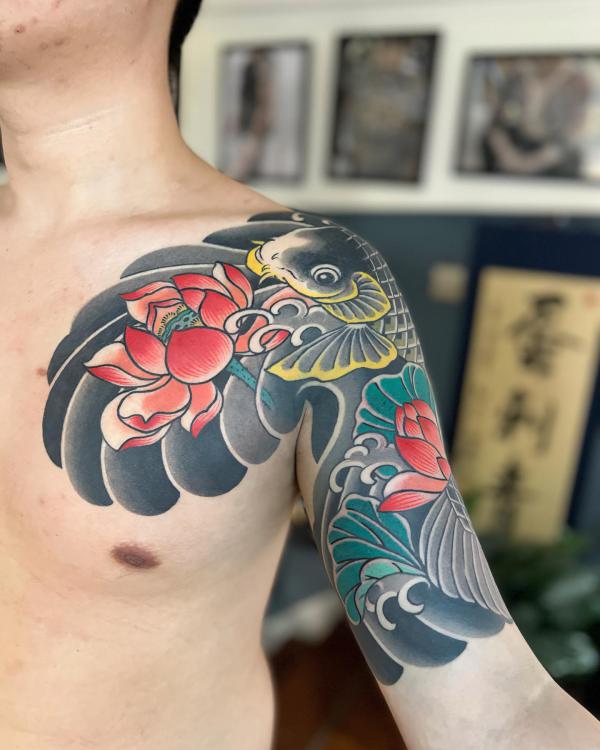 Lotus and koi fish chest to arm tattoo