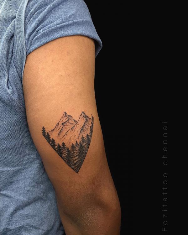 Mountain range and trees tricep tattoo