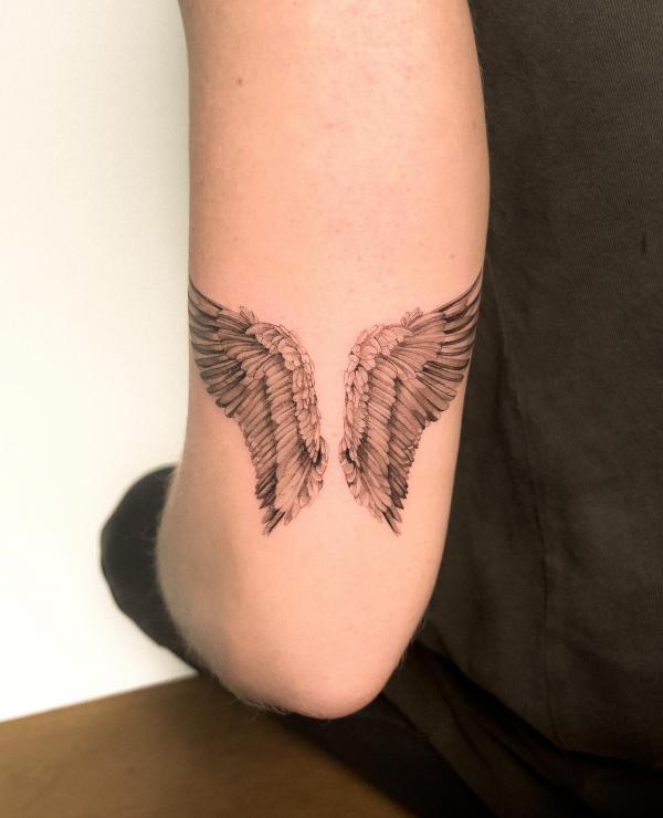 Realistic wings tricep tattoo