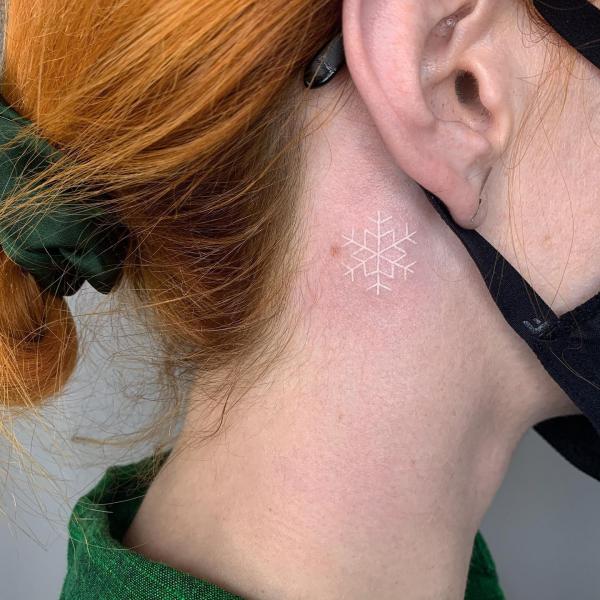 Snowflake white ink tattoo behind ear